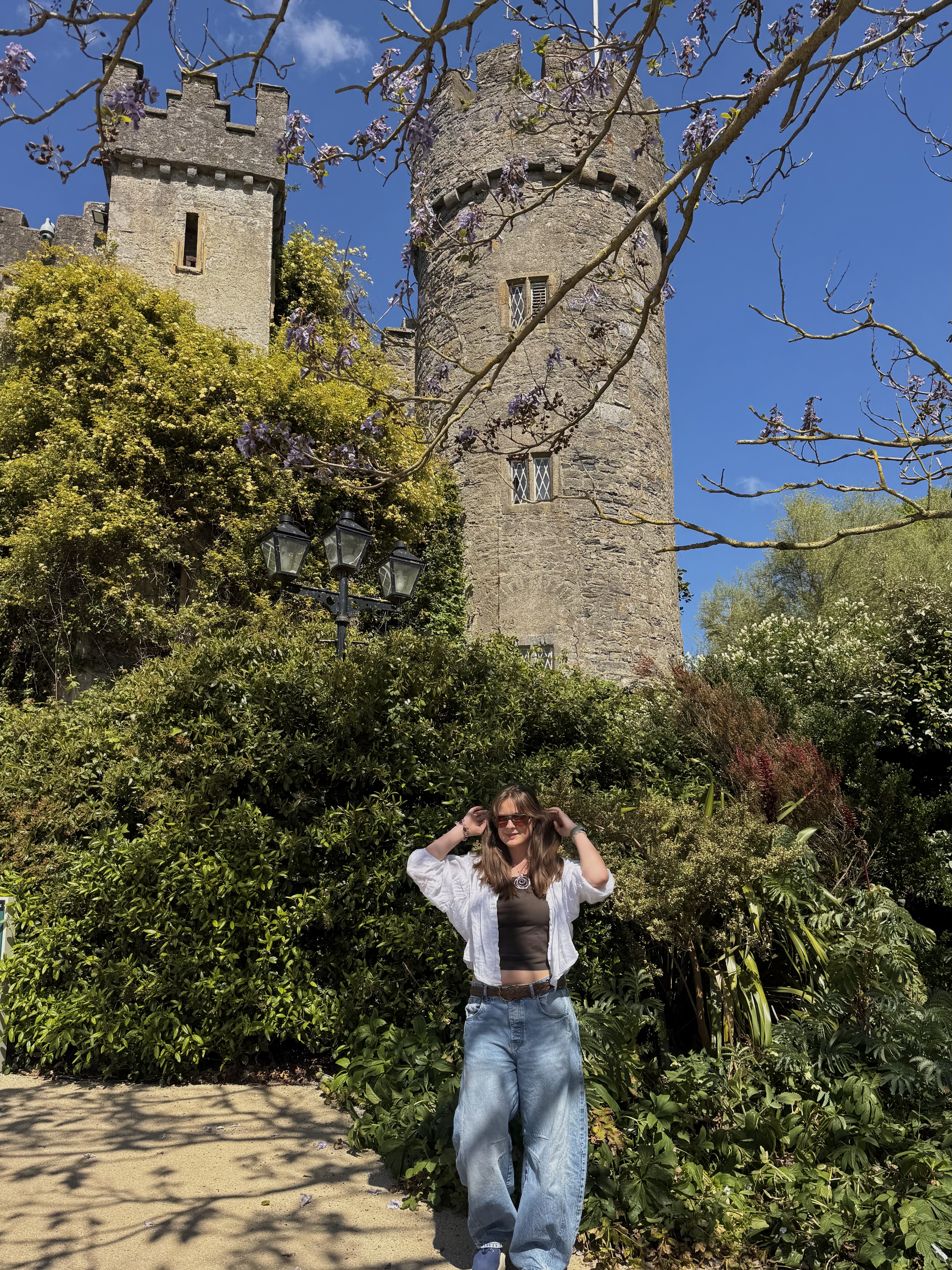 Mia standing in front of a grey cobblestone castle