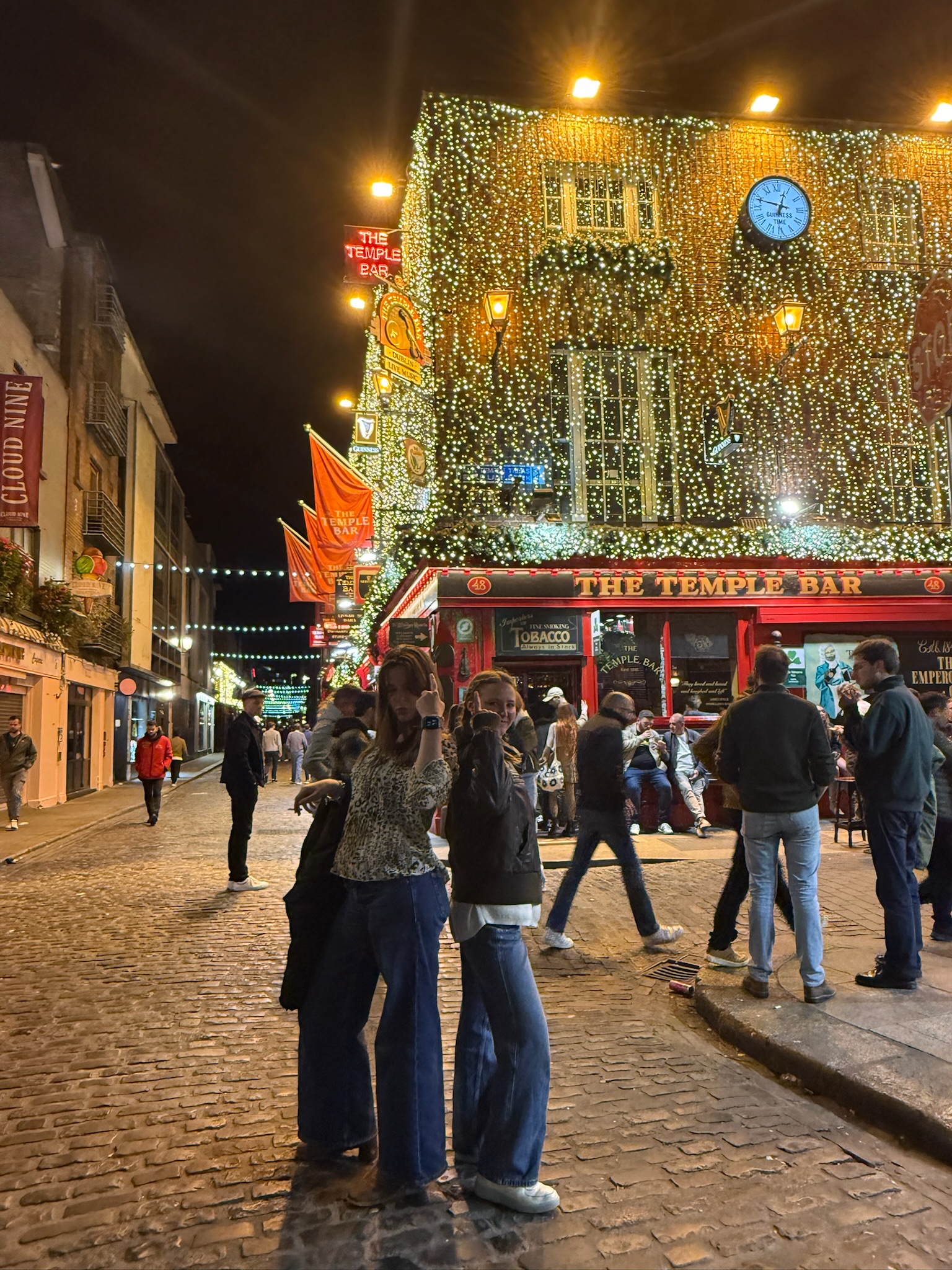 two girls outside of a traditional Irish pub with lights