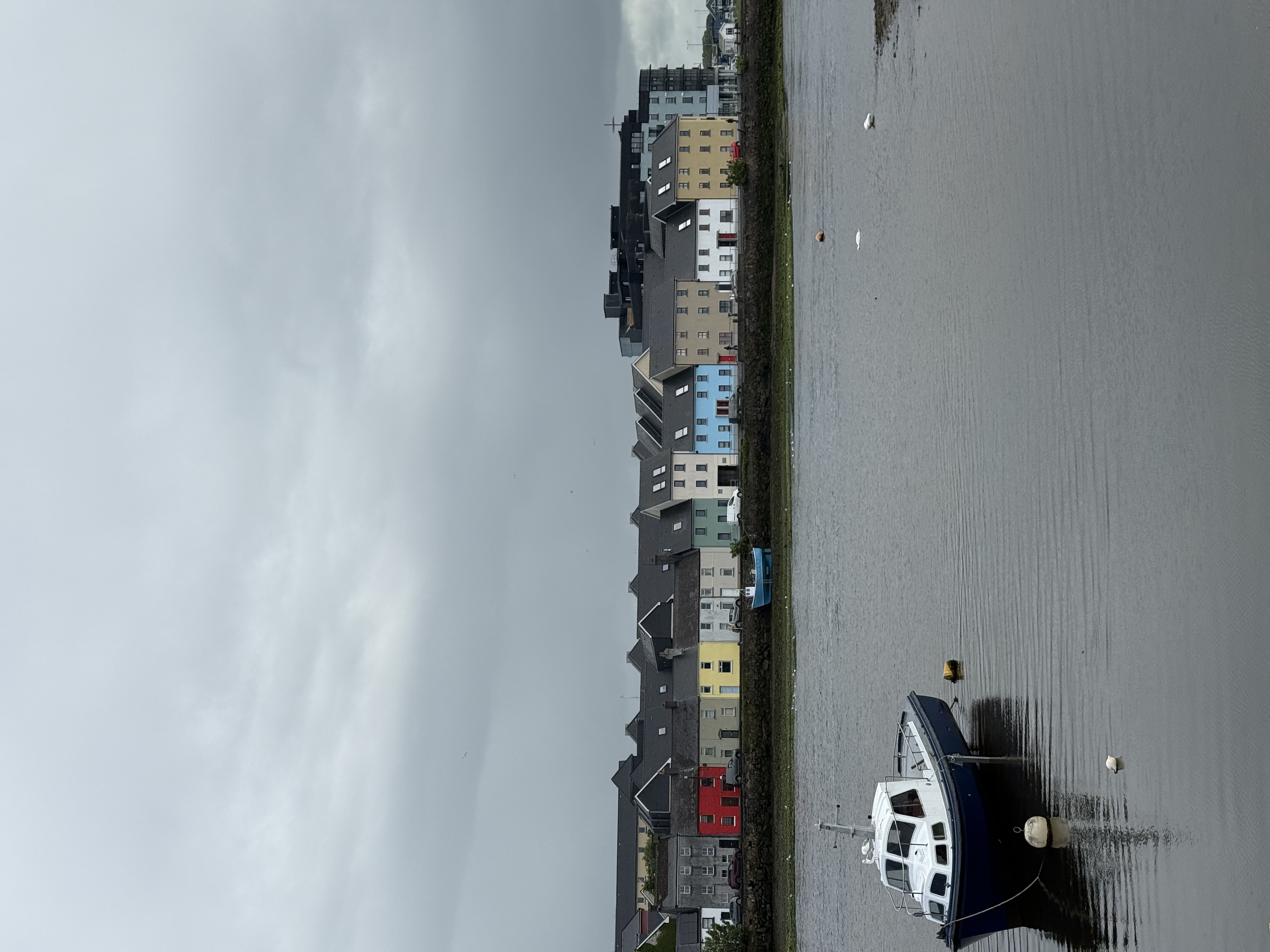 a boat in a river in front of colorful buildings