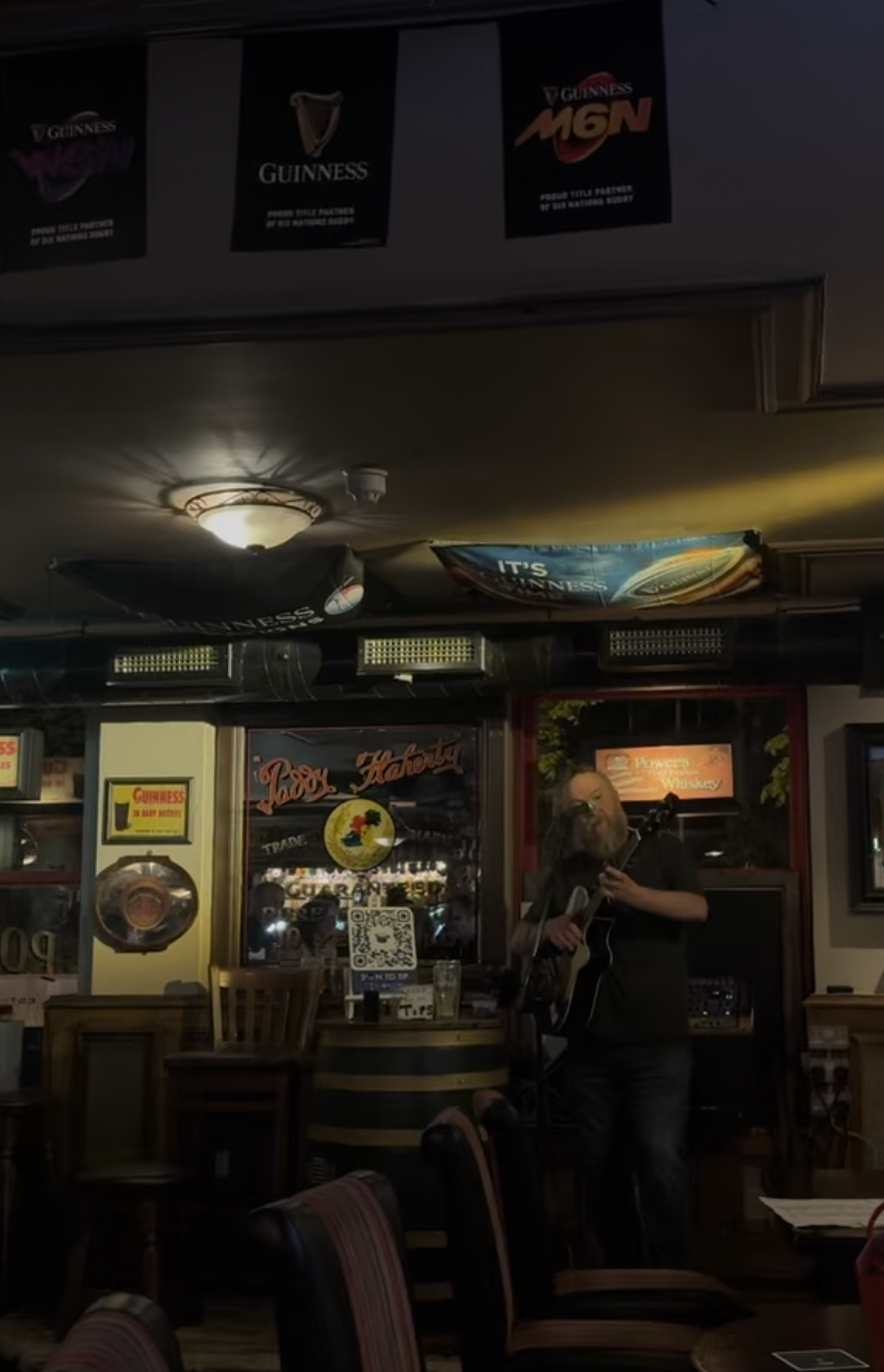 A man in a pub playing guitar