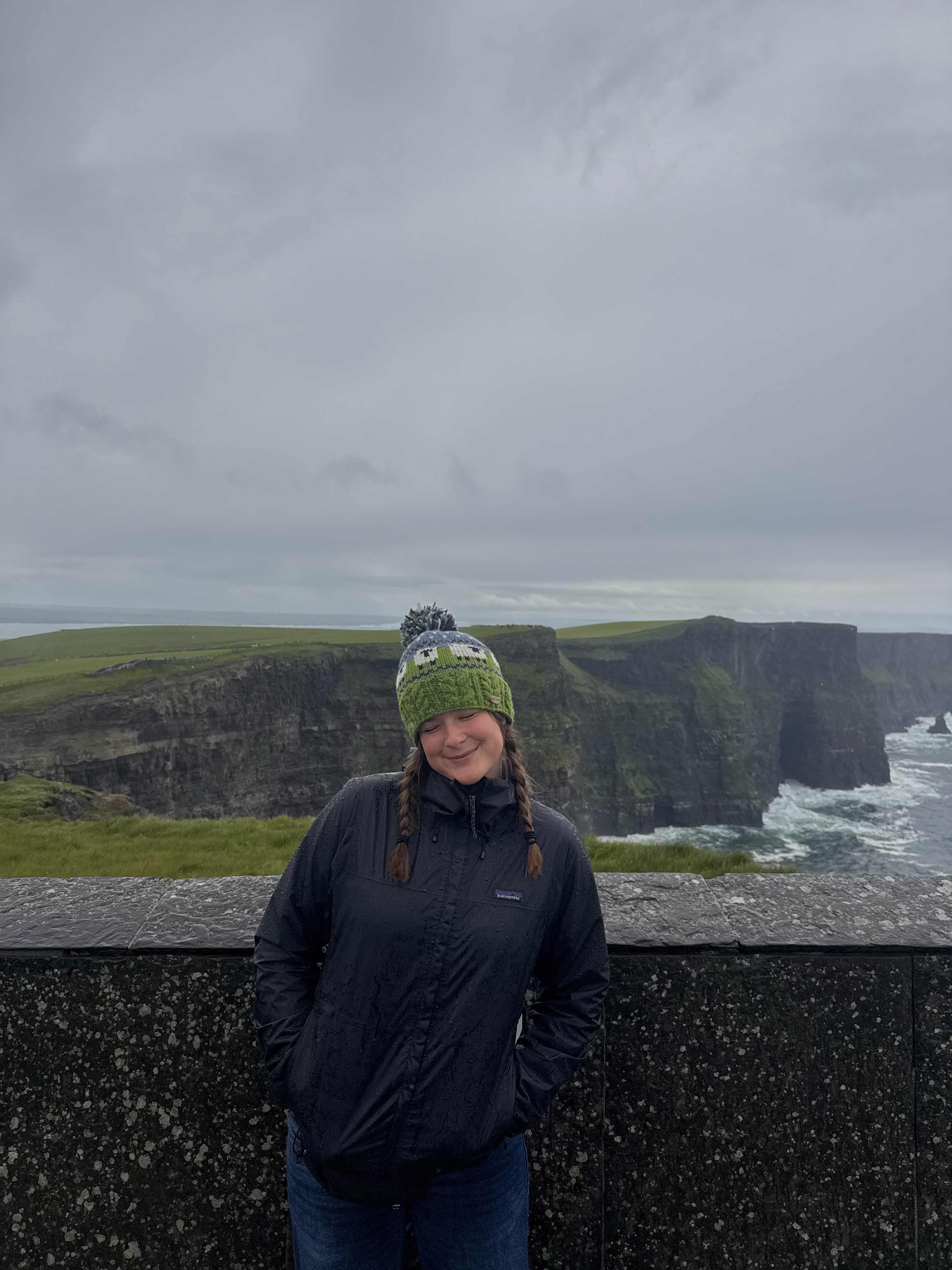 mia next to a cliff and the ocean behind her