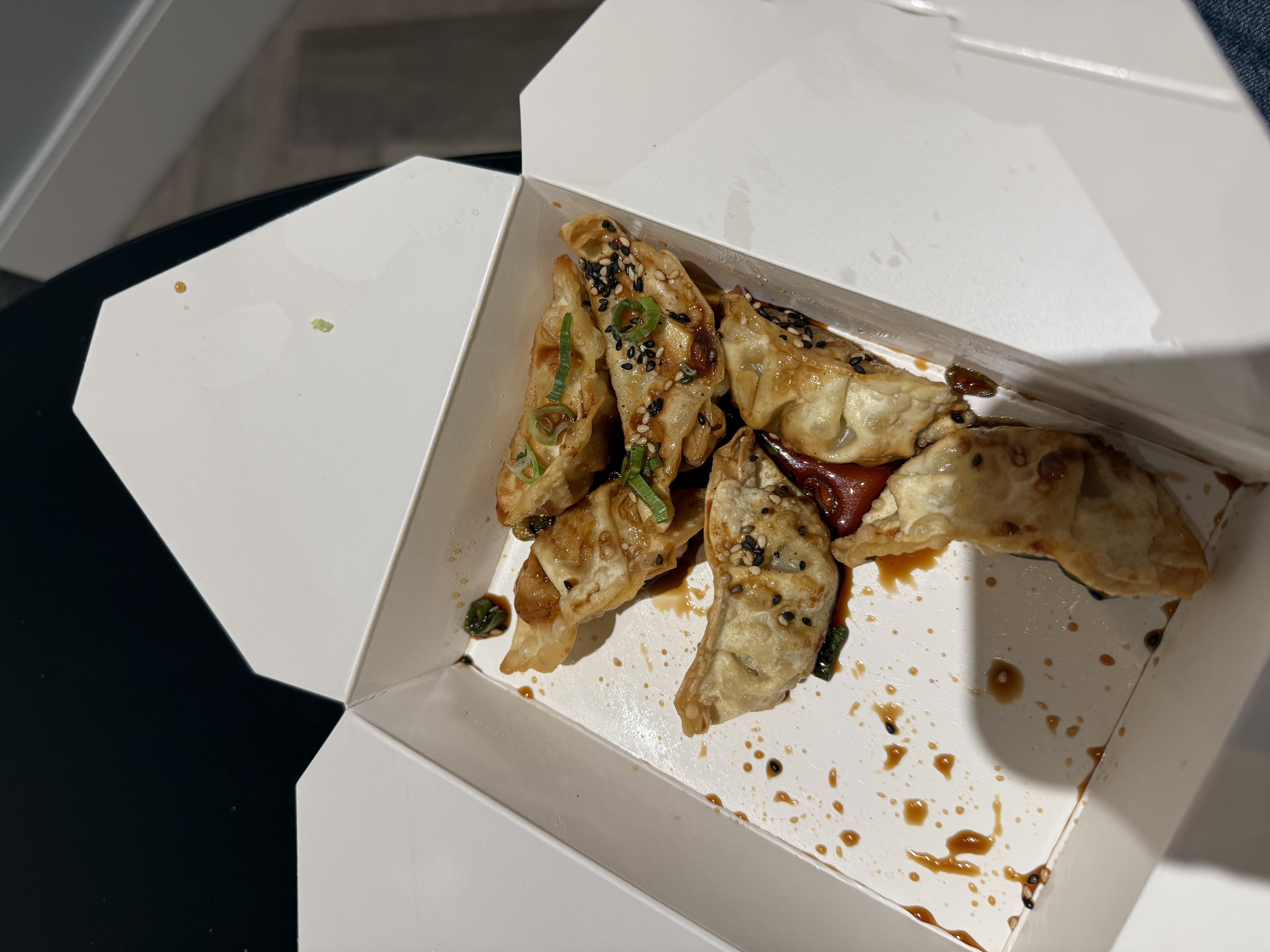 six fried dumplings with a dark sauce